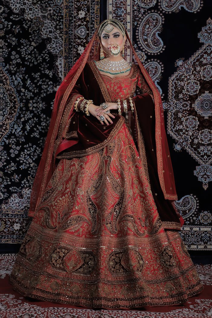 Beautiful Indian bride in traditional red lehenga posing indoors, exuding grace and style.